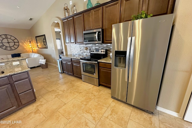 2969 Pony Cir, Lake Havasu City, AZ 86406 - kitchen featuring appliances with stainless steel finishes, arched walkways, tasteful backsplash, lofted ceiling, and open floor plan