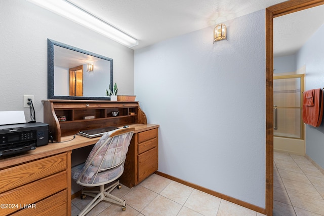 office area featuring baseboards, built in study area, and light tile patterned floors