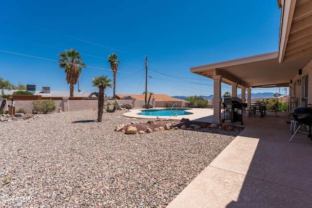 view of yard featuring a patio area, a fenced in pool, outdoor dining space, and a fenced backyard
