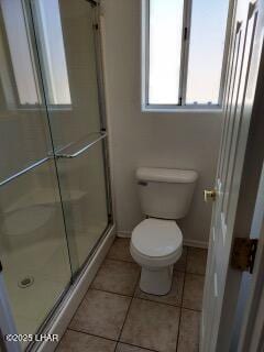 bathroom with baseboards, tile patterned flooring, toilet, and a shower stall