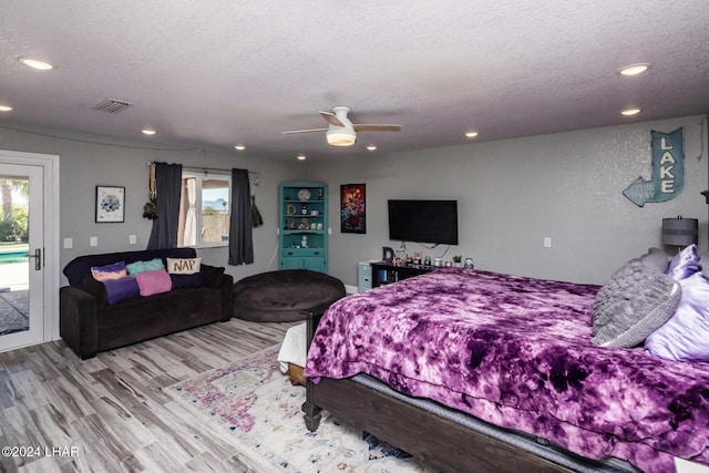 bedroom with access to exterior, light hardwood / wood-style floors, a textured ceiling, and ceiling fan