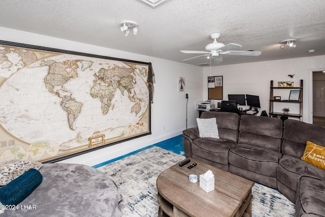 living room with ceiling fan and a textured ceiling