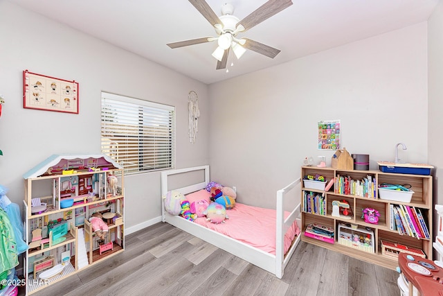 bedroom with a ceiling fan, baseboards, and wood finished floors