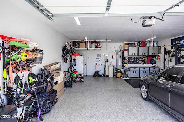 garage featuring water heater, a workshop area, and a garage door opener