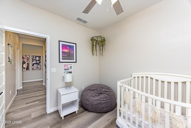 bedroom featuring visible vents, ceiling fan, light wood-style flooring, and baseboards