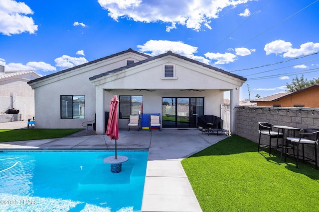 rear view of property with a fenced in pool, a yard, stucco siding, a patio area, and fence