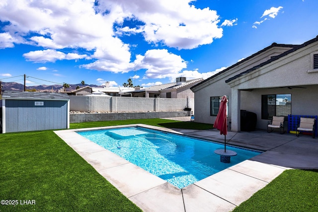 view of swimming pool featuring a storage shed, a lawn, a patio, a fenced backyard, and an outbuilding