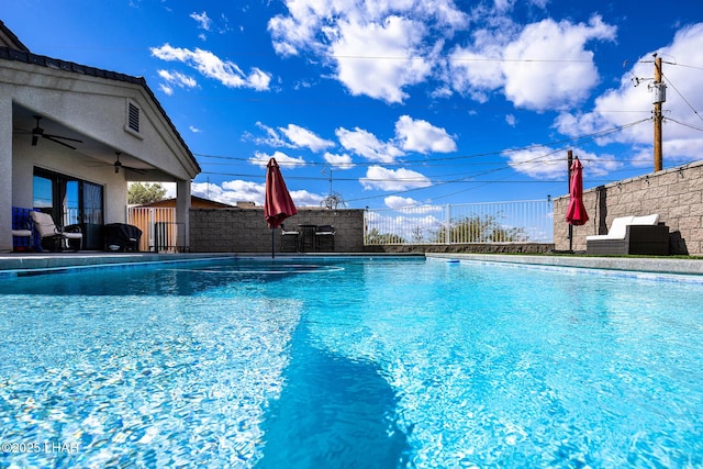 view of swimming pool with a ceiling fan, a fenced in pool, and fence