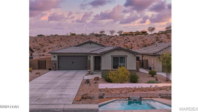 ranch-style home featuring a fenced in pool and a garage