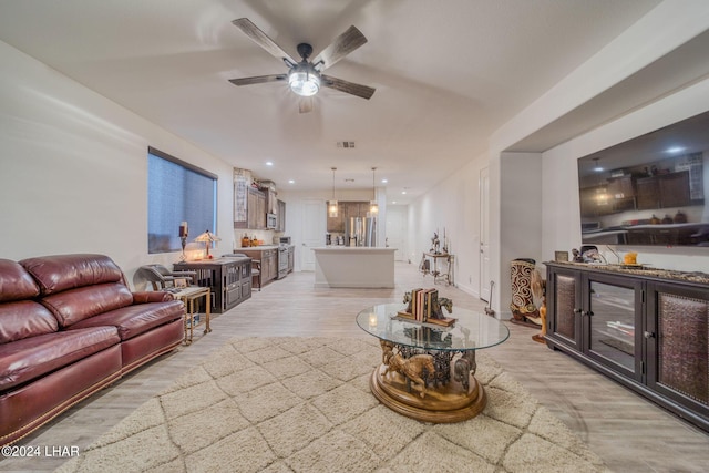 living room with ceiling fan and light wood-type flooring