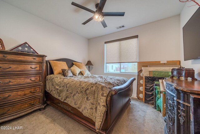 carpeted bedroom featuring ceiling fan and a fireplace