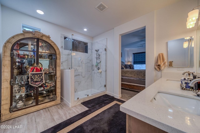 bathroom with hardwood / wood-style flooring, vanity, and an enclosed shower