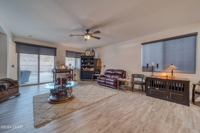 living room featuring light hardwood / wood-style flooring and ceiling fan