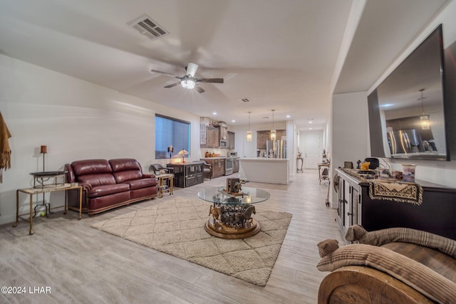 living room featuring ceiling fan and light hardwood / wood-style floors