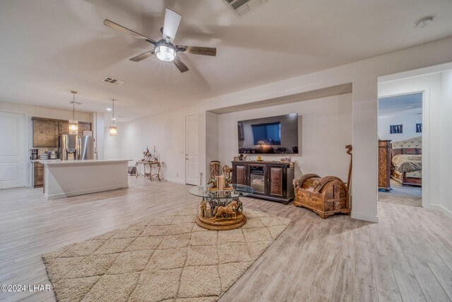 living room with ceiling fan and light wood-type flooring