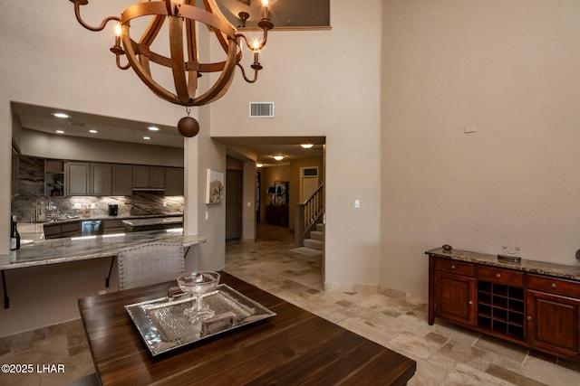 1415 Mcculloch Blvd N Unit 102, Lake Havasu City, AZ 86403 - living room with an inviting chandelier, a towering ceiling, stairs, and visible vents