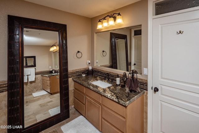 1415 Mcculloch Blvd N Unit 102, Lake Havasu City, AZ 86403 - bathroom with wainscoting, tile walls, two vanities, and a sink