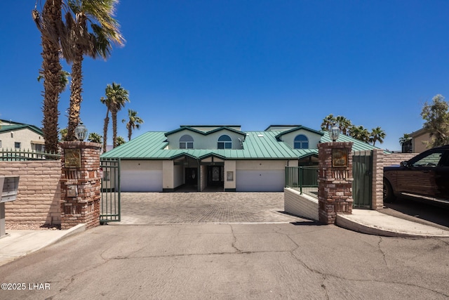 1415 Mcculloch Blvd N Unit 102, Lake Havasu City, AZ 86403 - view of front facade featuring a standing seam roof, metal roof, decorative driveway, fence, and an attached garage