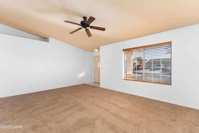 carpeted empty room with vaulted ceiling and ceiling fan