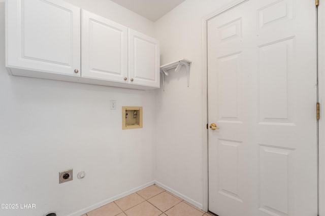 clothes washing area featuring electric dryer hookup, light tile patterned floors, hookup for a washing machine, and cabinets