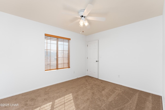 spare room with ceiling fan and carpet