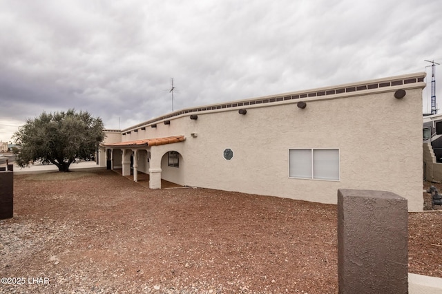 back of property featuring stucco siding