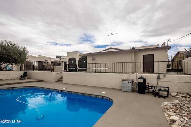 view of swimming pool featuring a patio area, fence, and a fenced in pool