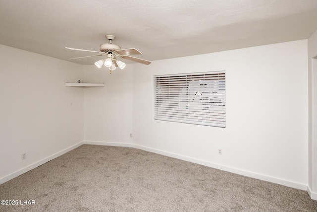 carpeted spare room featuring a ceiling fan and baseboards