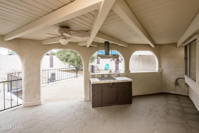 view of patio / terrace with ceiling fan and fence