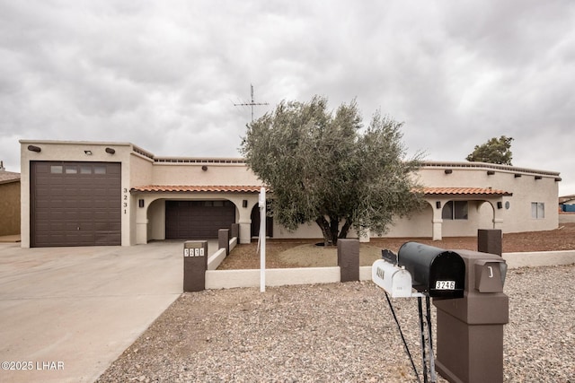 view of front facade featuring a tile roof, an attached garage, driveway, and stucco siding