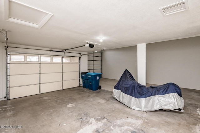 garage featuring visible vents and a garage door opener