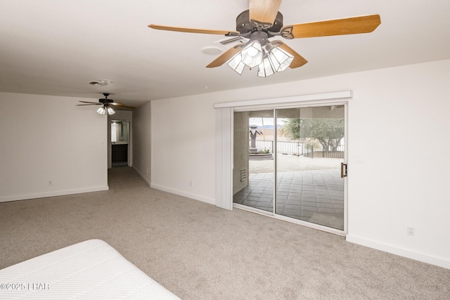 carpeted empty room with baseboards, visible vents, and ceiling fan