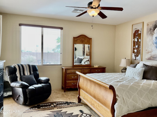 bedroom with visible vents, light colored carpet, and a ceiling fan