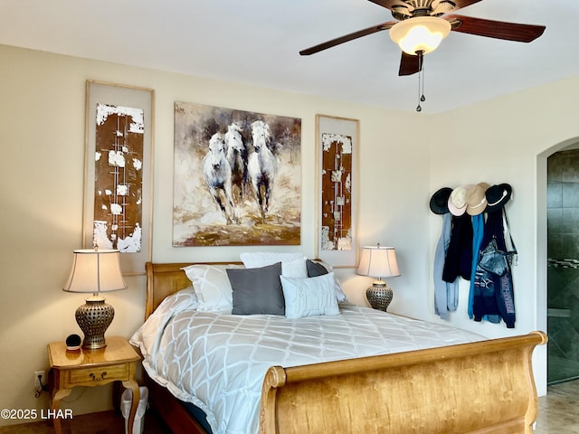 bedroom with arched walkways and a ceiling fan