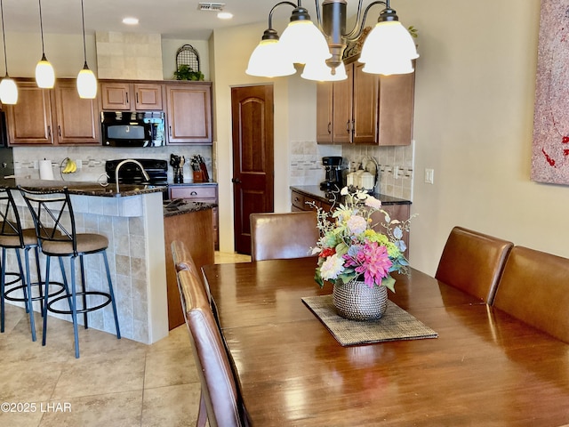 dining room with visible vents, a notable chandelier, and light tile patterned flooring