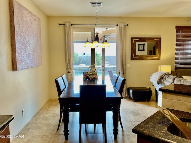 dining space featuring light tile patterned floors, visible vents, and an inviting chandelier