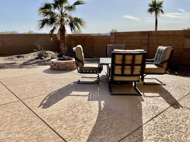 view of patio with outdoor dining area, fence, and an outdoor fire pit