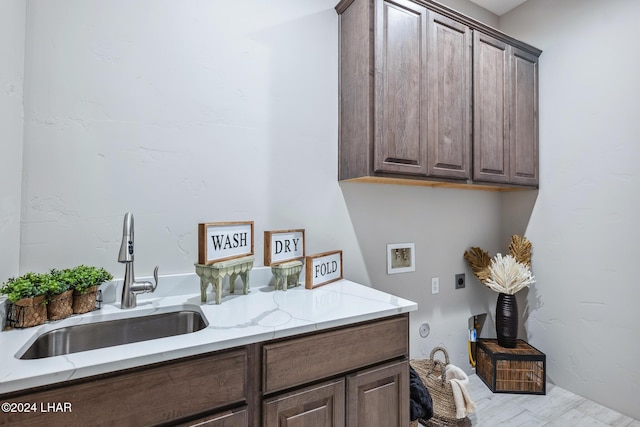 clothes washing area with cabinets, washer hookup, hookup for an electric dryer, and sink