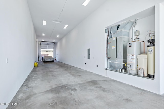 garage with heating unit, electric panel, and water heater