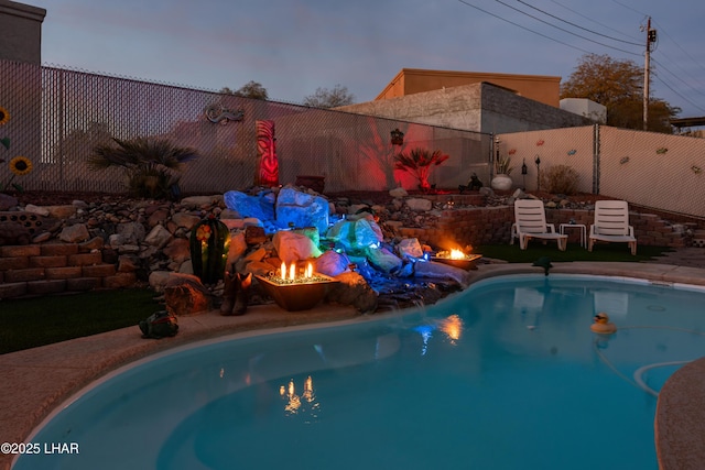 pool at dusk with an outdoor fire pit