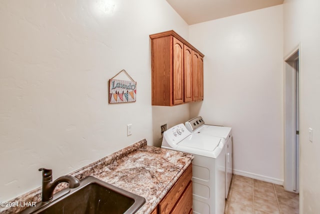 laundry area with sink, light tile patterned floors, washer and clothes dryer, and cabinets