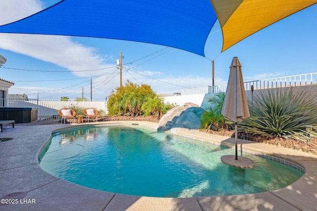 view of swimming pool with a fenced in pool, a patio, a water slide, and a fenced backyard