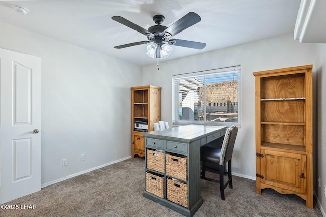 home office featuring a ceiling fan, baseboards, and carpet floors