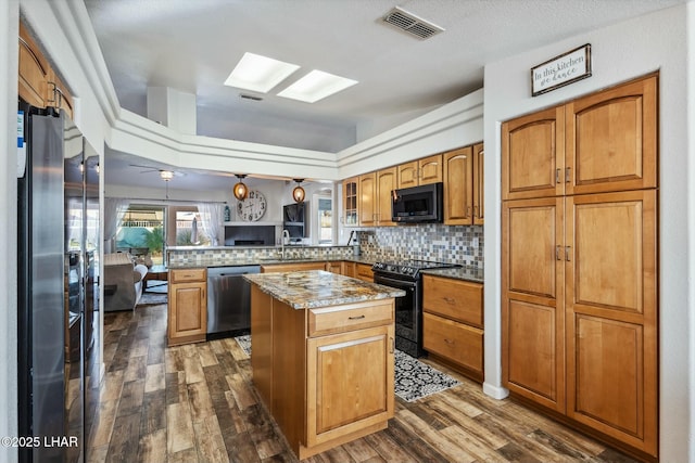 kitchen featuring visible vents, backsplash, a peninsula, and stainless steel appliances