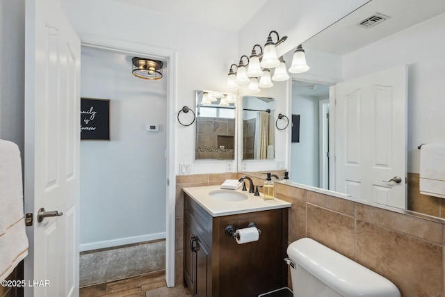 full bathroom with vanity, wood finished floors, visible vents, tile walls, and toilet