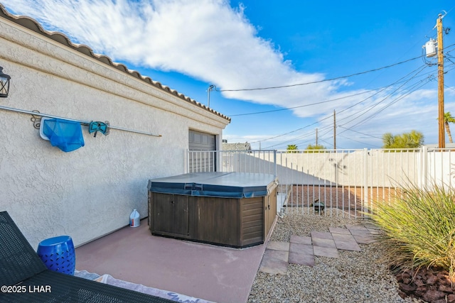 view of patio with fence and a hot tub