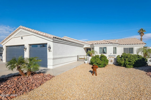 view of front of house with stucco siding, concrete driveway, an attached garage, and a tiled roof