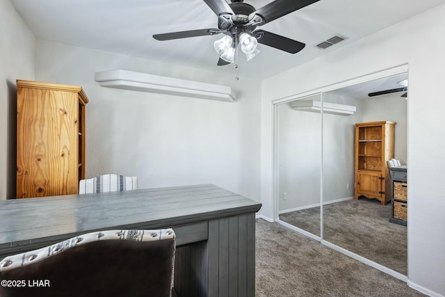 unfurnished office featuring visible vents, baseboards, carpet, and ceiling fan