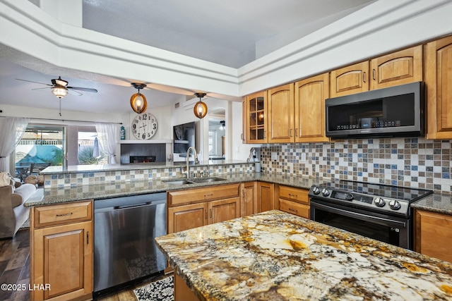 kitchen featuring dishwasher, electric range, open floor plan, and a sink