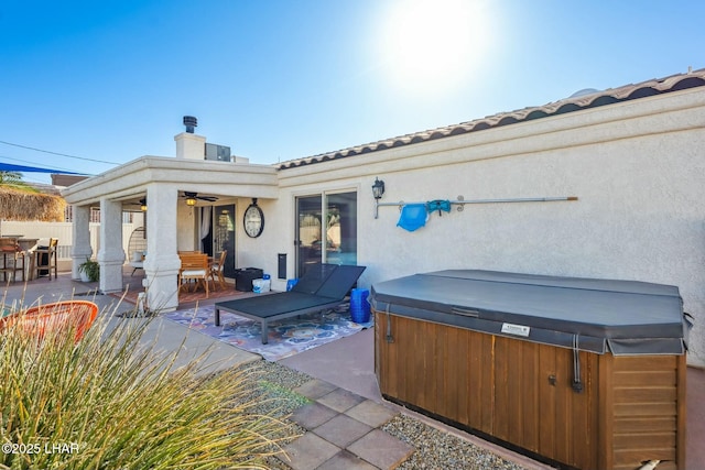 view of patio / terrace with a hot tub, a ceiling fan, and fence